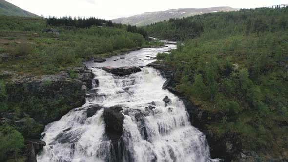 Aerial View Of River Cascading Down Rocks Surrounded By Green Wilderness Landscape In Hardangervidda alt