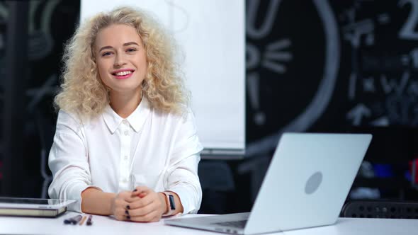 Portrait of Successful Young Female Teamleader Having Good Time Indoor Sitting at Table alt