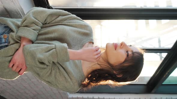 Woman Staying Near Window and Flirting at the Camera the Sun Illuminate Her Face alt