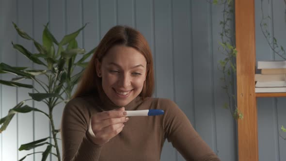 Happy Woman Takes a Pregnancy Test and She Is Pregnant alt