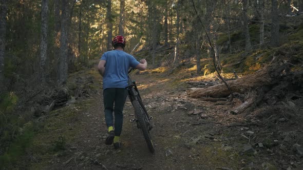 mountain biker going up a mountain with his bike ready for adventure Texada Island British Columbia alt