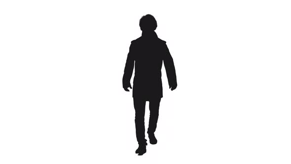 Silhouette Of Stylish Man In Coat Walking Towards The Camera