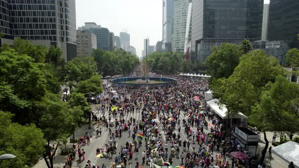 backwards drone shot of the crowd gathered to celebrate the pride parade in mexico city on paseo de alt