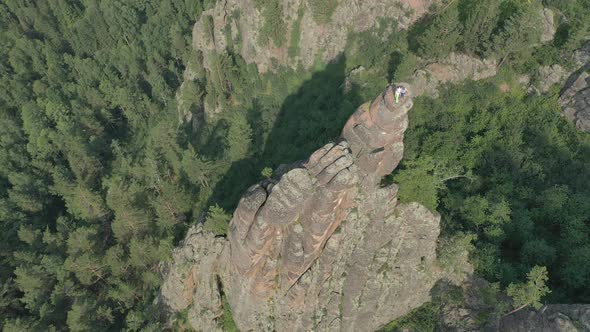 Aerial View of Two Men Standing on Top of a Mountain in the Forest in Summer.