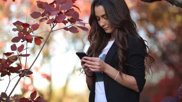 The Girl Communicates in Social Networks While Being in Nature alt