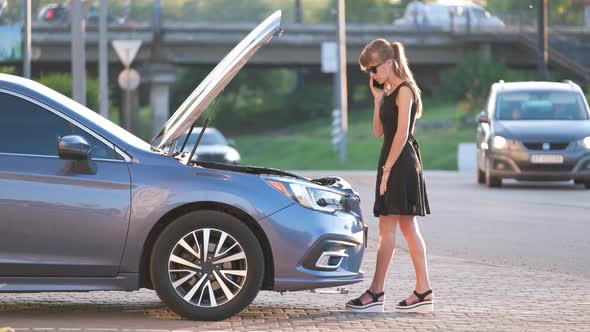 Helpless Woman Standing Near Her Car with Open Bonnet Calling Road Service for Help alt