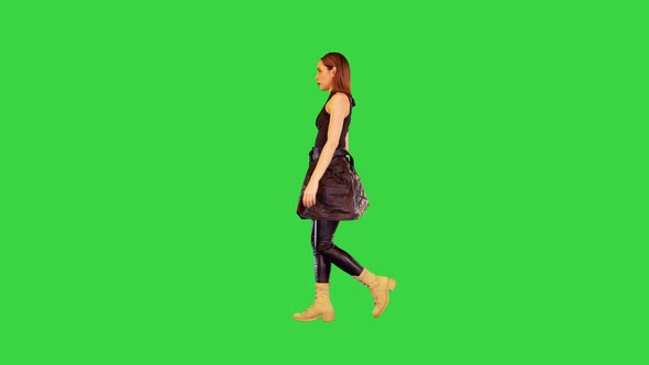Gamecharacter Girl in Black Military Clothes Walks on a Green Screen Chroma Key