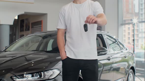 Cropped Shot of a Midsection of a Male Customer Holding Out Car Keys To His Newly Bought Car. Man alt