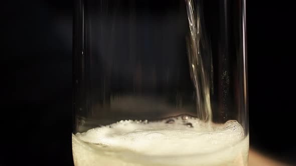 Pouring sparkly beverage into a glass, raising the carbonization foam from the trapped air - Close u alt