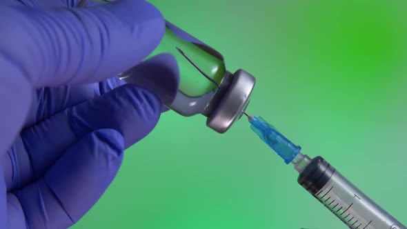 Measles Vaccine Into Syringe on Green Background