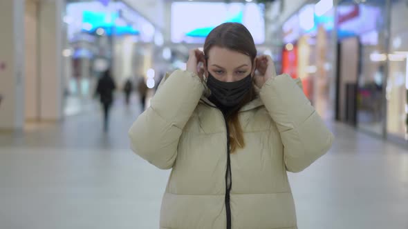 Young Woman Standing and Looking at Camera in Shopping Mall or Trade Center