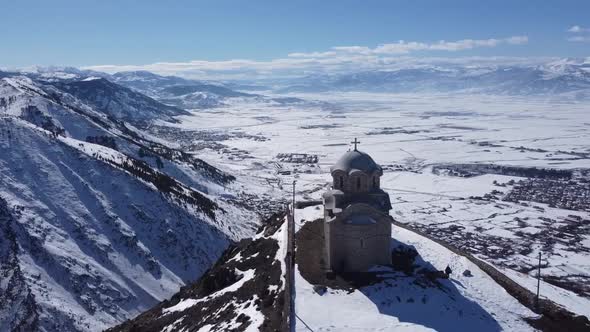 Church and Cross on a Snowy Mountain in Korca, Albania