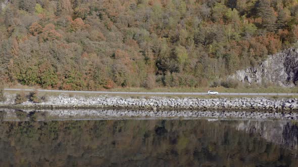 Car Reflected in the Calm Waters of a Fjord in the Fall alt
