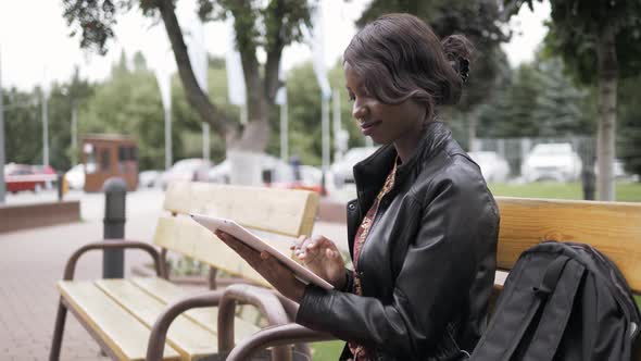 Laughing Young African American Female Girl Holding a Touch Pad Tablet PC Outdoor, Black Student alt
