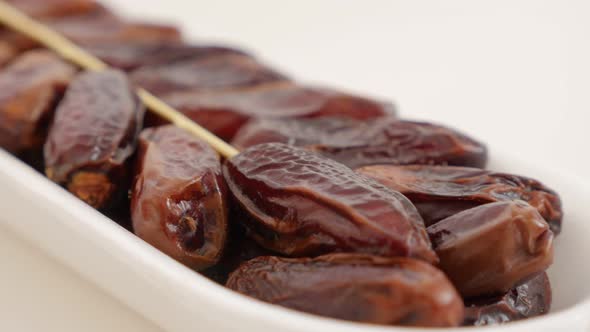 Exotic dates palm fruit on white reflective surface 4K 2160p UltraHD footage - Phoenix dactylifera t alt