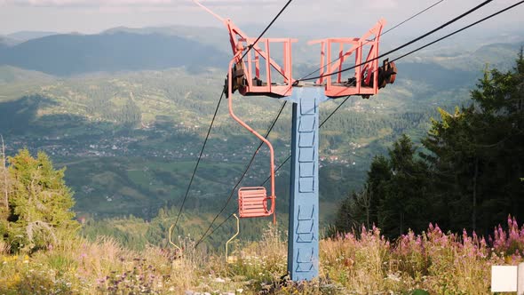 Empty mountain ski chairlift with steel cables on the top of hill alt
