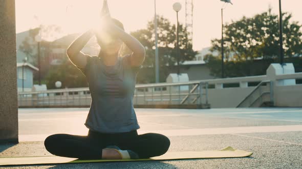 Beautiful young female practicing yoga, sitting in padmasana on a yoga mat. alt