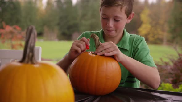 Boy carving pumpkin for Halloween