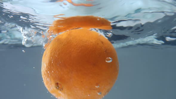 Orange Falling in Water Underwater View