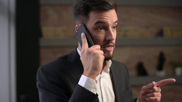 Frustrated and angry company manager talking expressively on the phone alt