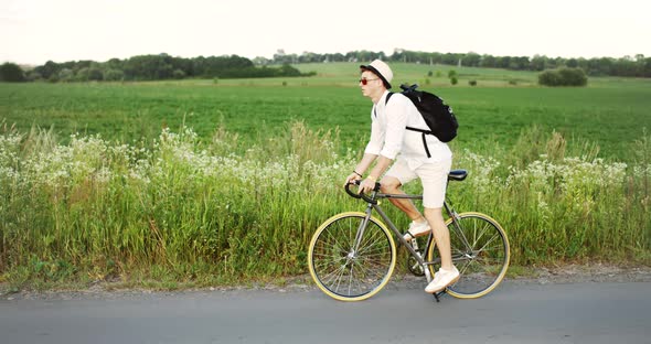 Man Riding Bicycle on Field Road