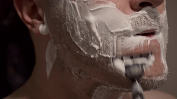 A Person Shaves with a Razor Shaving Foam is Applied to the Skin