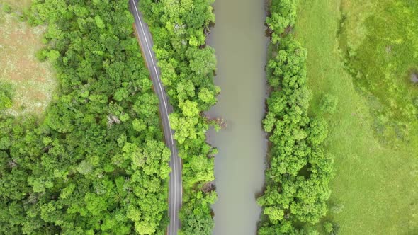 Flight with drone over a road around a river