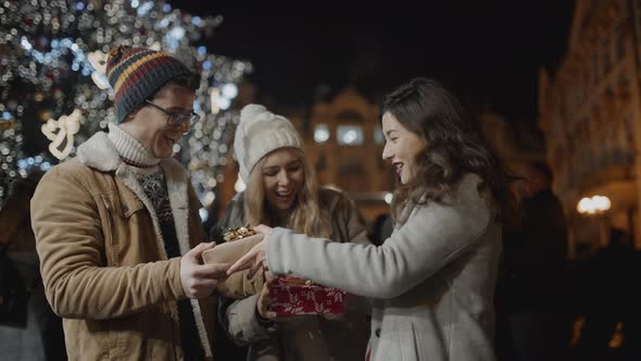 Friends Presenting Gifts to Each Other at Xmas Night in Prague alt