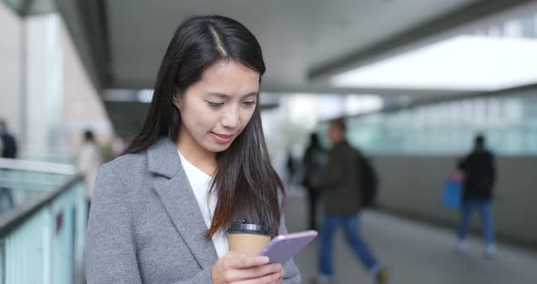 Businesswoman using looking at smart phone alt