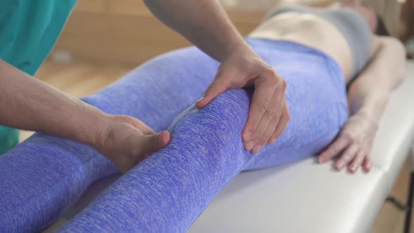 Therapist Chiropractor Treats Injured Knee Athletes Female Patient Close Up alt