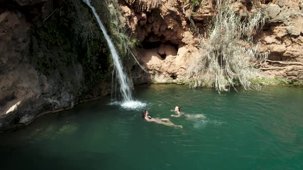 Girls Swimming In Beautiful Waterfall Lake