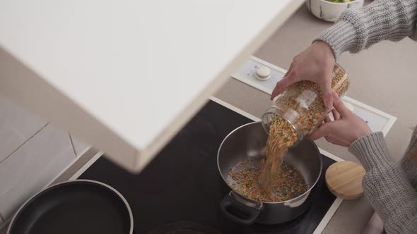 Woman Pouring Grains Into a Bowl for Cooking