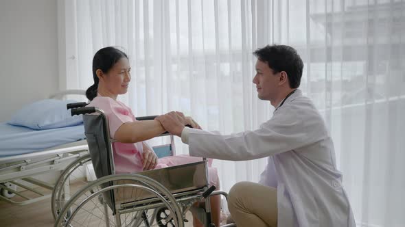Doctor comforting patient in wheelchair due to accident
