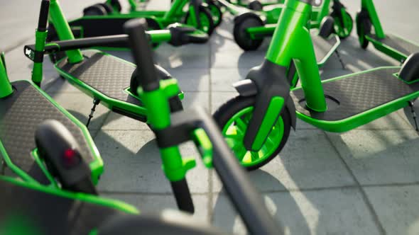 Countless green electric scooters left on a sidewalk by irresponsible users 4kHD alt