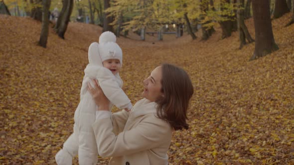 Mom with baby among fallen leaves