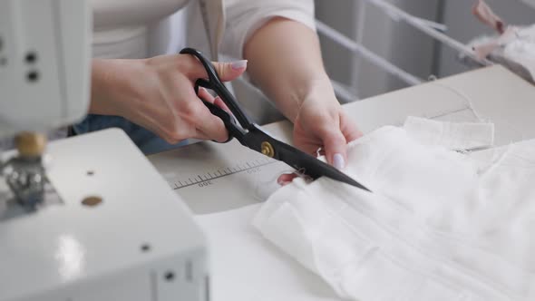 Seamstress Cuts Fabric in the Workplace