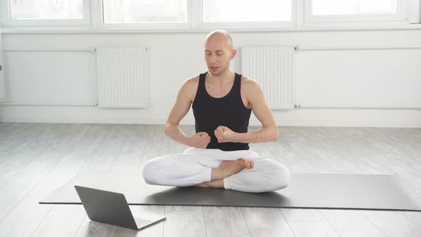Yogi Male with Laptop Doing Yoga Teaching Students