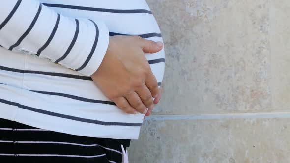 Pregnant Belly In Striped Clothes Against Stone Wall Outdoor