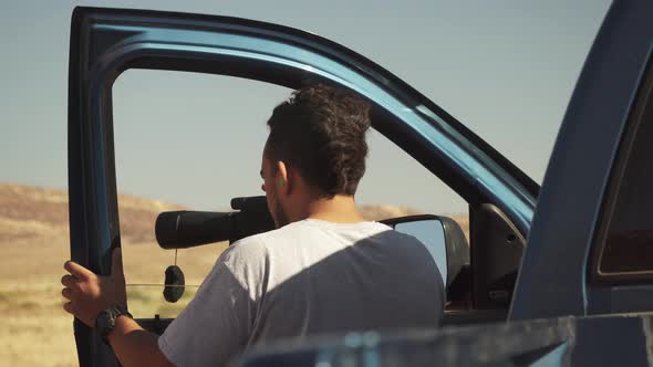 a young hunter looks into the spotting scope to check out target groupings.  His father opens the re alt