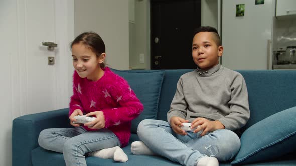 Moving Shot of Diverse Multiethnic Kids Playing Video Game Indoors alt