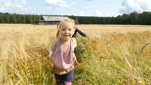 Little Girls Running Cross The Wheat Field. Happy Kids Playing On Wheat Field