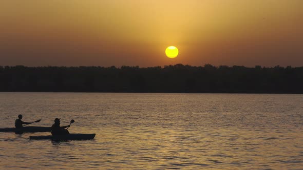 Father and Son Kayaking on a Lake at Sunrise