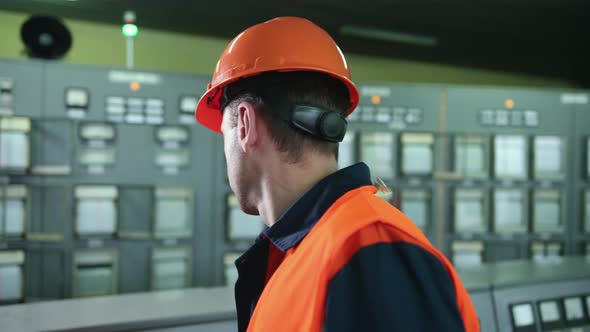Engineer Wearing Orange Protective Mask Checking Temperature Pipes in Control alt