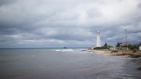 Seascape with Beautiful White Lighthouse Against Stormy Sk and Sea