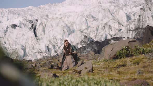 Traveller Carrying Guitar Case On Rocky Hill Next To Glacier alt