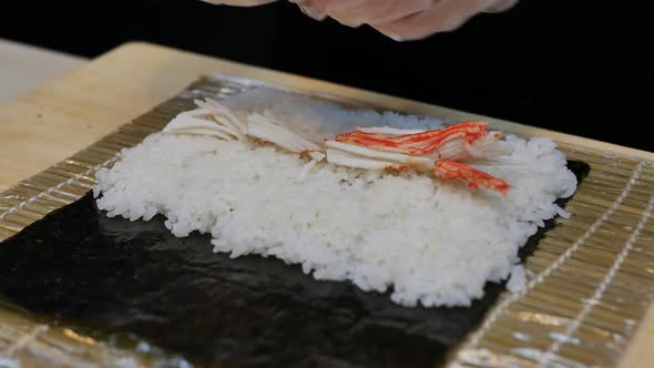 Sushi Chef Prepares a Roll
