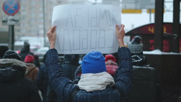 Protesting People March with Banners on Snowy Streets in Russia During Riot