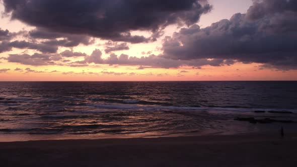Aerial drone in flight across the coast at sunset