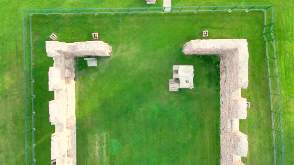 Remnants of old stone mill preserved in Falls Park, South Dakota. Green grass all around.