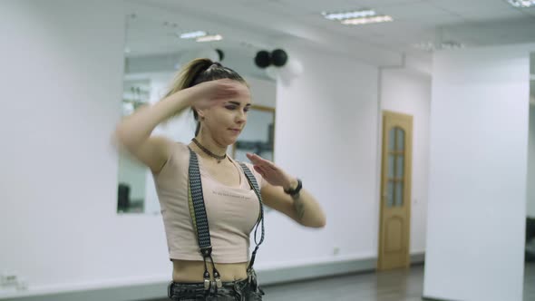 Medium shot of caucasian dancer choreographer performing freestyle animation in a dance studio alt